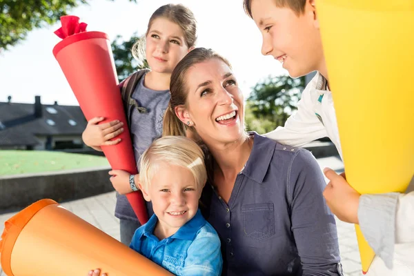 Vrouw en kinderen bij inschrijving dag met school kegels — Stockfoto