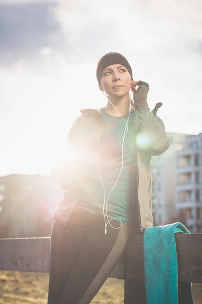 Junge Frau bereit für Outdoor-Workout Musik hören durch — Stockfoto