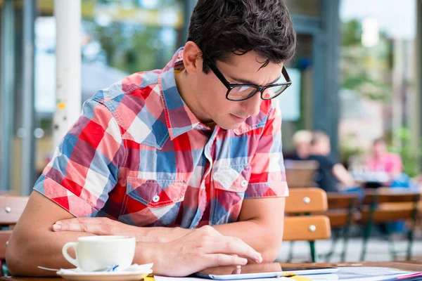 Ο άνθρωπος, πίνοντας τον καφέ στην καφετέρια του δρόμου ανάγνωση σε συσκευή tablet — Φωτογραφία Αρχείου