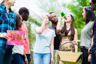 Çok kültürlü grup birlikte içme oyunu oynarken