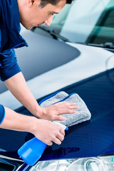 Manos limpiando coche con limpiador de pulverización y toalla de microfibra — Foto de Stock