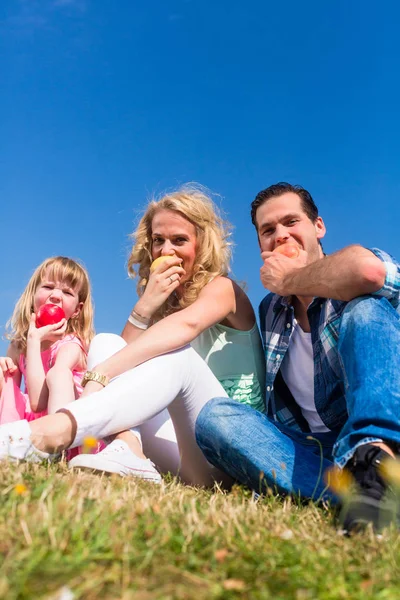 Pais e filha comendo maçãs — Fotografia de Stock