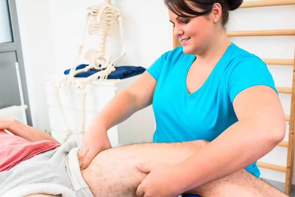 Physical therapist massages male leg — Stock Photo, Image