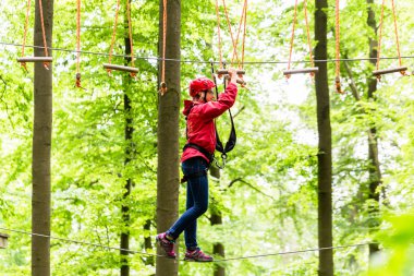 Yüksek ip parkuru tırmanışı platformu ulaşan çocuk