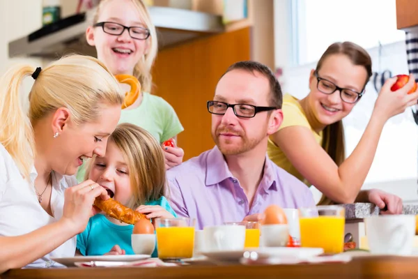 Familie på kjøkkenet spiser frokost sammen – stockfoto