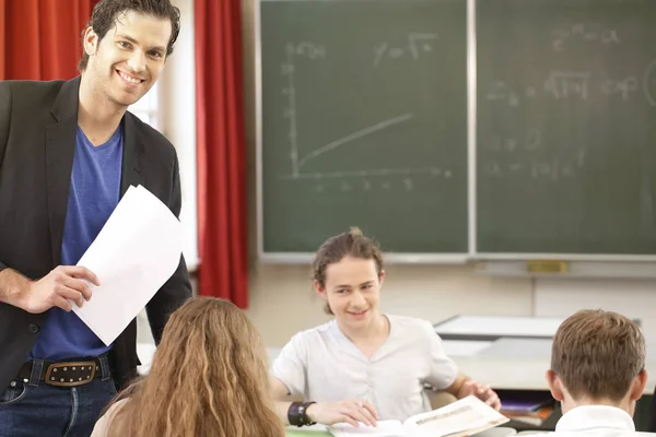 Professor ensinando ou educar no conselho uma classe na escola — Fotografia de Stock