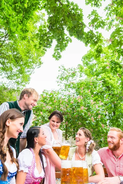 Waitress serving beer in beer garden — Stock Photo, Image