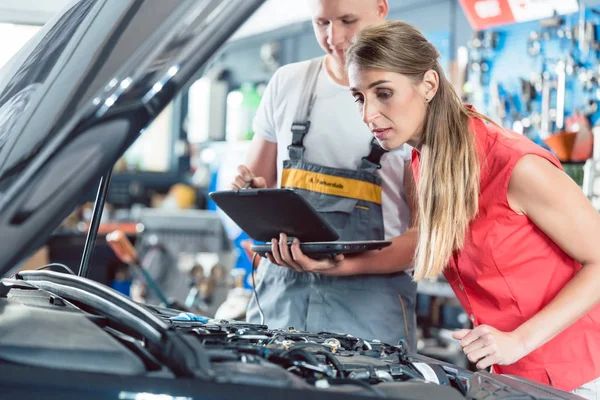 Mécanicien automatique montrant à un client les codes d'erreur du moteur scann — Photo