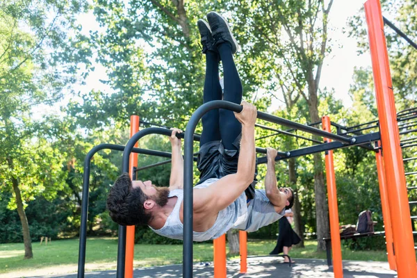 Dos jóvenes musculosos practicando ejercicio calisténico en un out — Foto de Stock