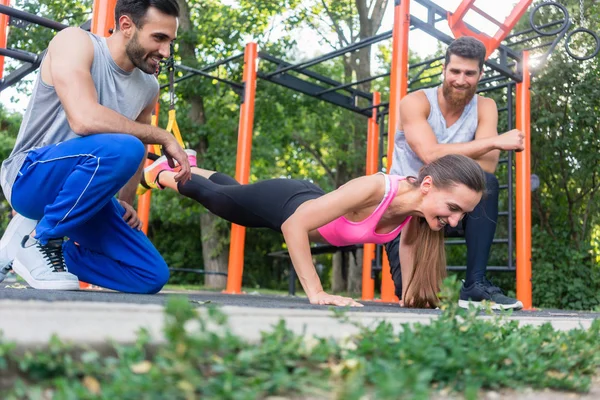 Fitte Frau macht Beinstreckung mit Suspension Trainer motiviert — Stockfoto