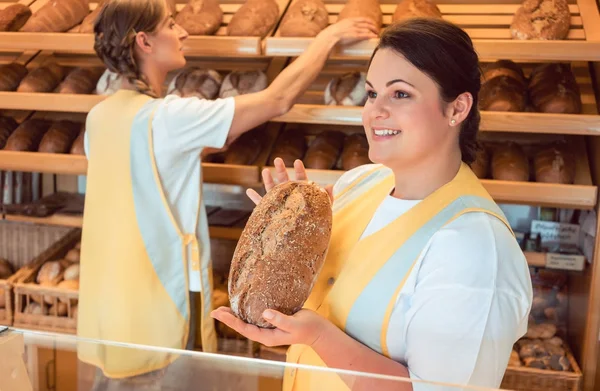 Twee salesladies verkoop van brood en andere producten in bakkerij winkel — Stockfoto