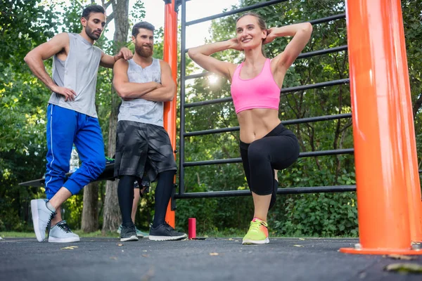 Mooie jonge vrouw die lacht terwijl durin Bulgaarse doen squats — Stockfoto