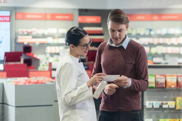 Joven leyendo la prescripción de un medicamento importante al lado — Foto de Stock