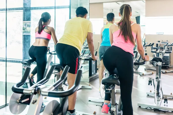 Fit women burning calories during indoor cycling class in a mode — Stock Photo, Image
