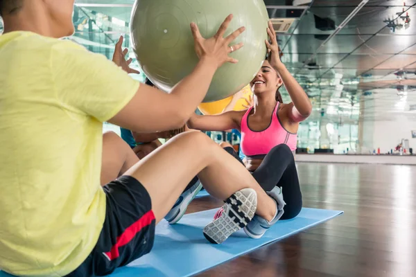 Mujer alegre dando la pelota de fitness a su compañero de entrenamiento wh —  Fotos de Stock