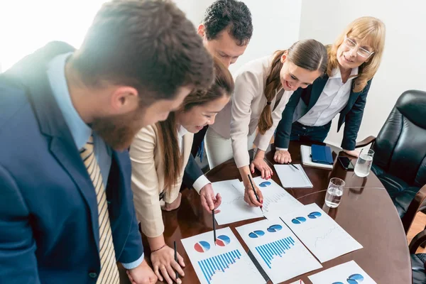 Equipo multiétnico de cinco especialistas dedicados sonriendo mientras un — Foto de Stock