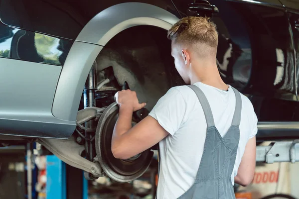 Doświadczony mechanik wymiana tarcze hamulcowe samochodu w mod — Zdjęcie stockowe