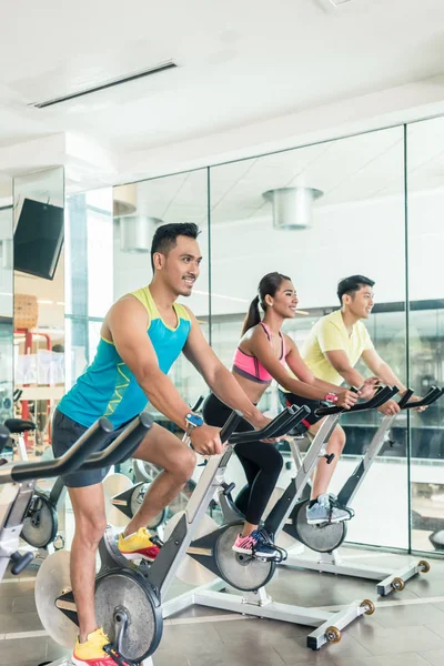 Handsome and confident young man during group class of HIIT indo — Stock Photo, Image