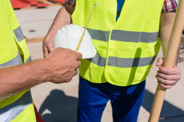 Close-up of the hand of a worker holding a measuring tape next t — Stock Photo, Image