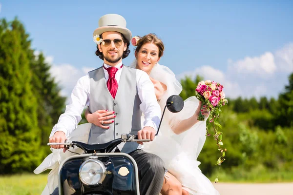 Pareja nupcial que conduce la vespa del motor que usa vestido y traje —  Fotos de Stock