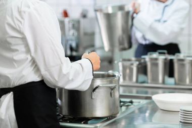 Şefler tencerelerde karıştırarak profesyonel catering mutfak soba