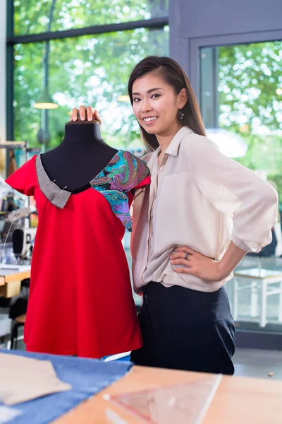 Aziatische tailor past kledingstuk ontwerp op etalagepop — Stockfoto