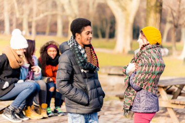 Afrikalı-Amerikalı genç adam açık havada kadın arkadaşıyla konuşuyor