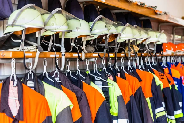 Helmets and uniforms in arsenal of fire fighters — Stock Photo, Image