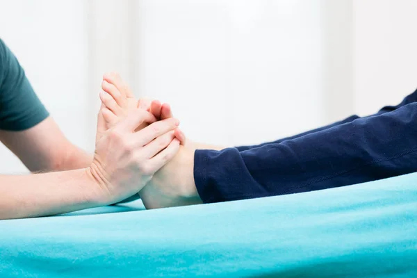 Patiënt met voet massage bij fysio — Stockfoto
