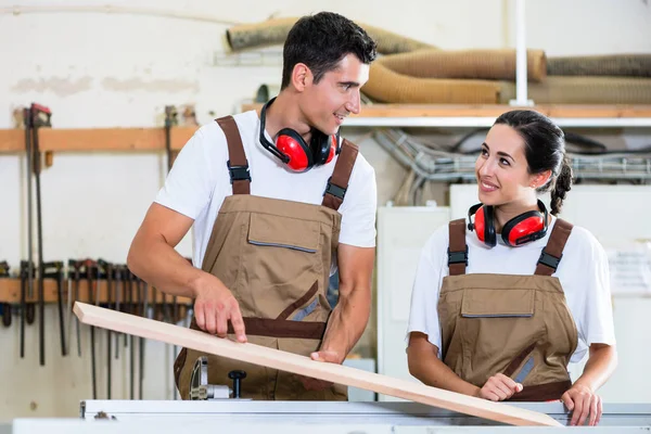 Carpinteiro e aprendiz trabalhando juntos em oficina — Fotografia de Stock