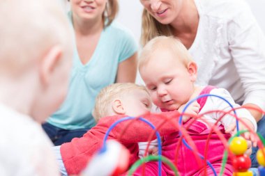 Renkli oyuncaklar ile oynama bir şirin sarışın bebek kız portresi