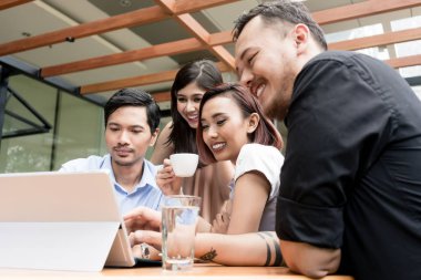 Gençlerin grup birlikte açık havada oturup bir kahve dükkanında dört Asya