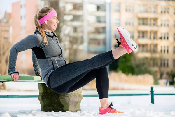 Woman stretching her limbs for sports exercise in winter — Stock Photo, Image