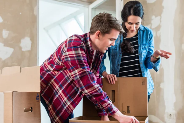 Jeune couple ouvrant des boîtes lors de la rénovation de la nouvelle maison après m — Photo