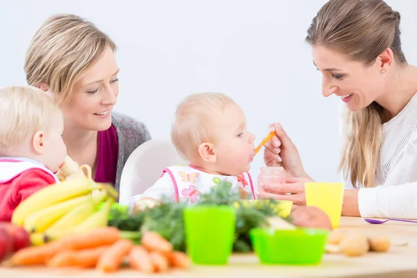 Portrait of a mother learning from her best friend how to prepare healthy food — Stock Photo, Image