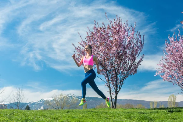Mulher que tem corrida fitness no sol de primavera — Fotografia de Stock
