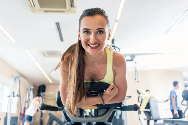 Портрет веселой женщины с низким углом обзора во время велосипедных тренировок — стоковое фото