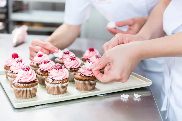 Mulheres em pastelaria trabalhando em muffins — Fotografia de Stock