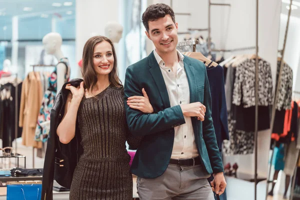 Жінка і чоловік купують одяг в модному магазині — стокове фото