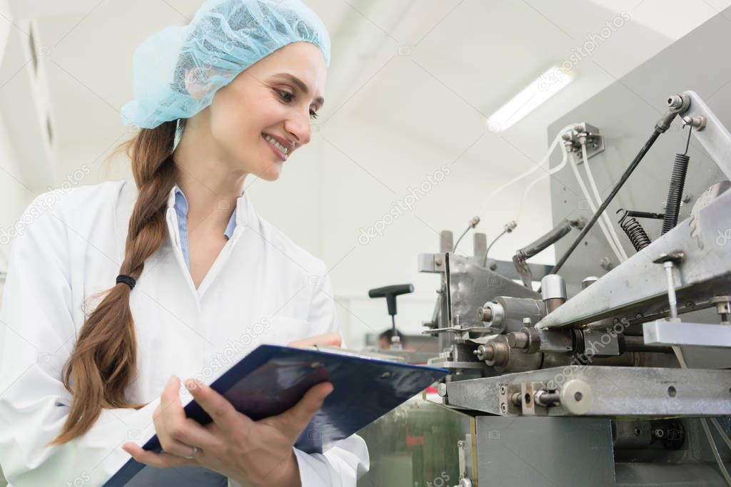 Happy woman technician checking quality of industrial machine