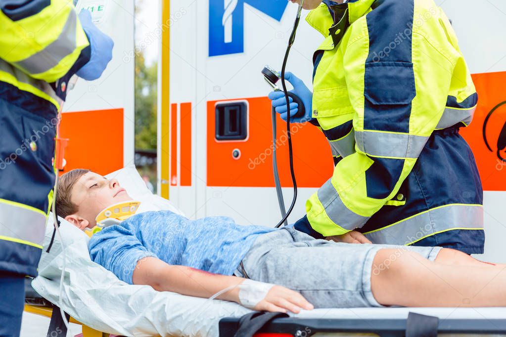 Emergency doctors putting injured boy in ambulance