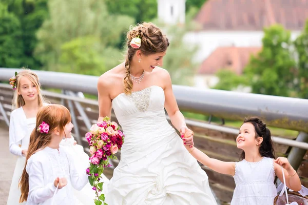 Wedding bride with flower children  outside at garden
