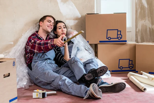 Feliz Joven Pareja Usando Overoles Mientras Descansa Después Mudarse Nuevo — Foto de Stock