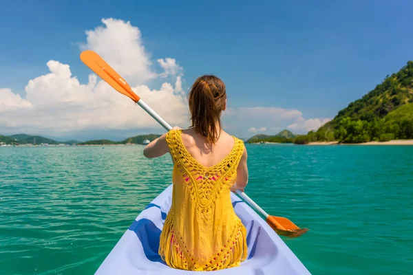 Jovem mulher remando uma canoa durante as férias na Ilha das Flores — Fotografia de Stock