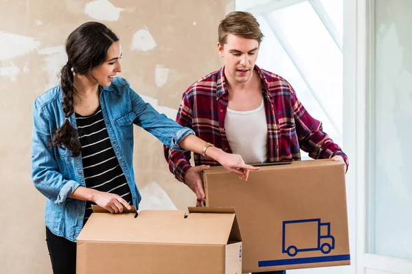 Junger Blonder Mann Mit Seiner Freundin Beim Öffnen Eines Kartons — Stockfoto