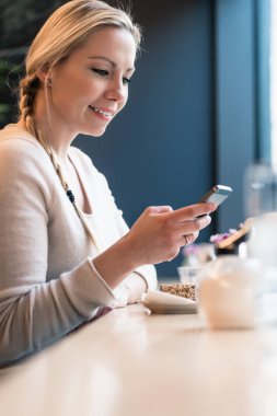Onun sosyal medya besleme kontrol bir tren kabinde telefonunu kullanan kadın