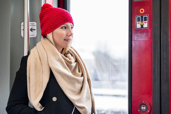 鉄道駅への到着を待っているドアの近くの中に立っている女性 — ストック写真