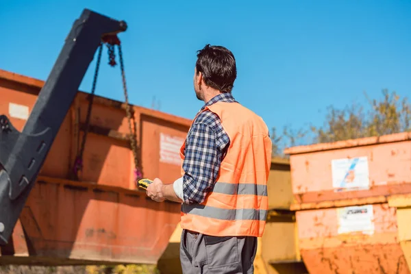 Werknemer op bouw site lossen container voor afval van t — Stockfoto
