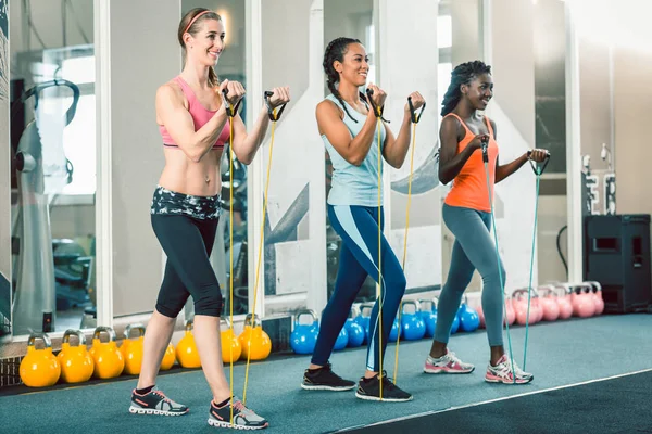 Full length of three fit women exercising with resistance bands — Stock Photo, Image
