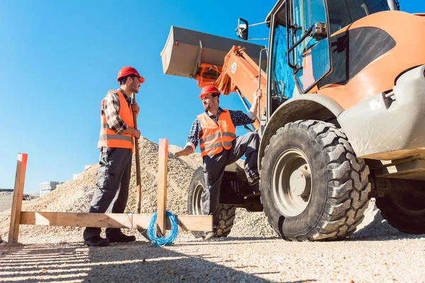 Trabajadores en obra discutiendo el uso de herramientas — Foto de Stock